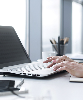 hands typing on a laptop